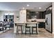 Modern kitchen with dark cabinets, granite countertops, stainless steel appliances, and a breakfast bar island at 7113 Forest Heights Ct, Las Vegas, NV 89166
