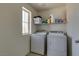 Functional laundry room with modern appliances, shelving for storage, and a bright window at 7113 Forest Heights Ct, Las Vegas, NV 89166