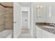 Well lit bathroom featuring tile surround, granite vanity and access to the laundry area at 7200 Pirates Cove Rd # 2089, Las Vegas, NV 89145
