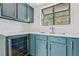 Stylish kitchen features teal cabinets, modern countertops, and a stainless steel beverage fridge at 7200 Pirates Cove Rd # 2089, Las Vegas, NV 89145