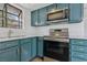 Updated kitchen boasts teal cabinets, stainless steel appliances, and modern countertops at 7200 Pirates Cove Rd # 2089, Las Vegas, NV 89145
