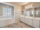 Bright bathroom with double vanity, soaking tub, and bright natural light at 7709 Tiny Tortoise St, Las Vegas, NV 89149