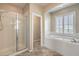 Bright bathroom with glass shower, soaking tub, and bright natural light at 7709 Tiny Tortoise St, Las Vegas, NV 89149