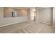 Open bonus room area with tan walls, neutral carpet, and an entrance to the upper floor at 7709 Tiny Tortoise St, Las Vegas, NV 89149