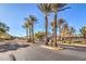 Gated entrance to a neighborhood adorned with mature palm trees and lush landscaping at 7709 Tiny Tortoise St, Las Vegas, NV 89149