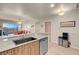 Modern kitchen with granite countertops and view of the living room and the outside mountains at 8255 S Las Vegas Blvd # 1907, Las Vegas, NV 89123