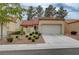 Exterior of single-Gathering home with a two car garage, a manicured lawn and desert landscaping at 8657 Prairie Hill Dr, Las Vegas, NV 89134