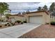 Exterior view of home highlighting the driveway and desert landscaping at 8657 Prairie Hill Dr, Las Vegas, NV 89134