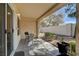 Cozy covered patio with outdoor seating overlooking a nicely landscaped backyard with mature trees at 8657 Prairie Hill Dr, Las Vegas, NV 89134