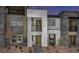Modern townhome showcasing gray stone and stucco exterior with multiple windows and small landscaped front at 883 Apatite Pl # Lot 57, Henderson, NV 89011