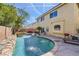 Resort-style backyard features a sparkling pool with a waterfall, lush landscaping, and seating areas at 10900 Calcedonian St, Las Vegas, NV 89141