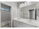 Bright bathroom features double sinks, white cabinets, and a shower-tub combo at 11484 Roncat Ct, Las Vegas, NV 89141