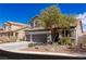 Charming two-story home with desert landscaping and a mature shade tree in the front yard at 11484 Roncat Ct, Las Vegas, NV 89141