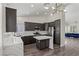 Modern kitchen features dark cabinets, a center island, and white countertops at 11484 Roncat Ct, Las Vegas, NV 89141