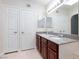 Spacious bathroom featuring dark cabinets, dual sinks, and a vanity mirror at 1212 Bass Dr # C, Henderson, NV 89014