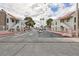 Gated community entrance featuring a wide road, symmetrical landscaping, and community buildings at 1212 Bass Dr # C, Henderson, NV 89014