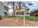 Community library box sitting on grass near stucco buildings, mature trees, and covered parking at 1212 Bass Dr # C, Henderson, NV 89014
