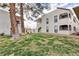 Beautifully landscaped exterior showing a grass lawn, stucco buildings, and mature shade trees at 1212 Bass Dr # C, Henderson, NV 89014