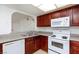 Efficient kitchen featuring white appliances and warm wood cabinetry at 1212 Bass Dr # C, Henderson, NV 89014