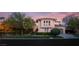 Inviting two-story home with a well-manicured lawn, mature trees, and tile roof at dusk at 1212 Muscato Ct, Las Vegas, NV 89144