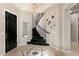 Inviting foyer with elegant black staircase and unique decor creates a striking entrance to the home at 1212 Muscato Ct, Las Vegas, NV 89144
