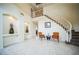 Grand foyer featuring tile floors, arched alcoves, and a curved staircase with white banisters and 2 chairs at 1304 Husson Ct, Las Vegas, NV 89142