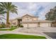 Elegant two-story home with a well-manicured lawn, palm tree, and a spacious driveway leading to multiple garages at 1304 Husson Ct, Las Vegas, NV 89142