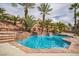 Backyard oasis with a sparkling pool, waterfall feature, palm trees, and lush landscaping at 1304 Husson Ct, Las Vegas, NV 89142