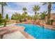 Backyard pool area featuring a waterfall feature and mature tropical landscaping at 1304 Husson Ct, Las Vegas, NV 89142