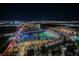 Aerial night view of a lit Topgolf venue, surrounded by palm trees and the city skyline at 135 Harmon Ave # 3220, Las Vegas, NV 89109