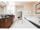 Elegant bathroom featuring a soaking tub, dark granite countertop, and access to the Primary bedroom at 135 Harmon Ave # 3220, Las Vegas, NV 89109
