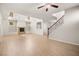 Open-concept living room features fireplace, staircase with iron spindles, and wood-look floors at 1640 Orange Daisy Pl, Henderson, NV 89012