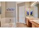 Bright bathroom featuring double sinks, a soaking tub, and neutral paint colors at 228 Lorryn Ln # 2, Boulder City, NV 89005