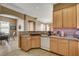 Well-lit kitchen featuring wood cabinetry, granite countertops and views into the dining area at 228 Lorryn Ln # 2, Boulder City, NV 89005