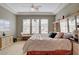 Spacious main bedroom with tray ceilings, artwork, tile flooring, and large windows at 228 Lorryn Ln # 2, Boulder City, NV 89005