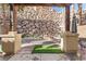 Inviting backyard with a stone wall, pergola, and a cozy fire pit area for outdoor relaxation at 23 Cerchio Basso, Henderson, NV 89011