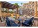 Outdoor seating area with stone wall, pergola, and patio, ideal for relaxing and enjoying the desert landscape at 23 Cerchio Basso, Henderson, NV 89011