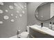 Stylish powder room features textured wallpaper and a modern sink at 23 Cerchio Basso, Henderson, NV 89011