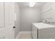 Clean and bright laundry room with modern white appliances and ample shelving for storage at 23 Cerchio Basso, Henderson, NV 89011