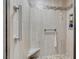 Bright shower featuring neutral tile, built in seat, and installed hand rails at 2508 Palmridge Dr, Las Vegas, NV 89134