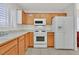 Well-lit kitchen featuring wood cabinets, white appliances, and ample counter space for meal preparation at 2608 Saltbush Dr, Las Vegas, NV 89134