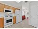 Bright kitchen features wooden cabinets, white appliances, and tile flooring at 2608 Saltbush Dr, Las Vegas, NV 89134