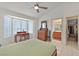 Bright main bedroom with a bay window, desk and stool, ceiling fan, and ensuite bathroom access at 2608 Saltbush Dr, Las Vegas, NV 89134