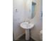 Powder room features a pedestal sink, oval mirror, and modern fixtures at 2765 Frosted Teal Ave, North Las Vegas, NV 89086