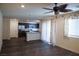 Open-concept living room with dark flooring, ceiling fan, and abundant natural light at 2765 Frosted Teal Ave, North Las Vegas, NV 89086