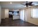 Open-concept living room with dark flooring, ceiling fan, and abundant natural light at 2765 Frosted Teal Ave, North Las Vegas, NV 89086