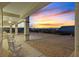 Covered back patio with stylish white seating offers views of the colorful sunset and surrounding landscape at 3042 Lake Barkley Rd, Henderson, NV 89052