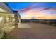 Backyard with covered patio, landscaping and sweeping views of the city and mountains at sunset at 3042 Lake Barkley Rd, Henderson, NV 89052