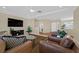 Spacious living room featuring hardwood floors, plush seating, a ceiling fan, and a large TV at 3042 Lake Barkley Rd, Henderson, NV 89052