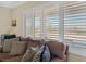Cozy living room with shuttered windows and decorative pillows, with a view to the desert landscape at 3042 Lake Barkley Rd, Henderson, NV 89052